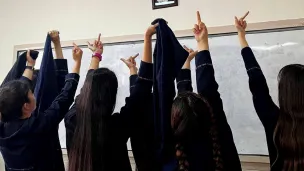 Iranske kvinner viser fingeren til et bilde av Khomeini