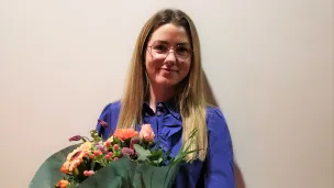 Ung kvinne med blomster i armene