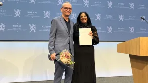 Leder av mannsutvalget Claus Jervell, gir rapporten til statsråd Lubna Jaffery
