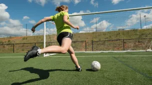 Jente i ferd med å skåre mål på fotballbanen