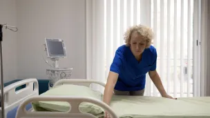 Voksen kvinne rer opp sykehusseng
