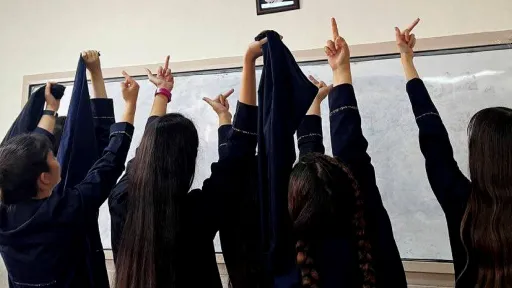 Iranske kvinner viser fingeren til et bilde av Khomeini
