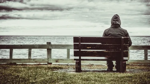 Mann på benk ved havet
