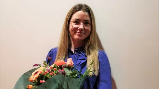 Ung kvinne med blomster i armene