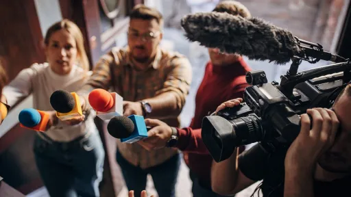 Journalister retter mikrofoner og kamera mot intervjuobjekt