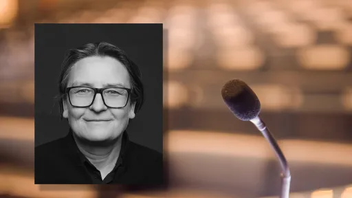 Portrettfoto av Ragnhild Hennum, dekan ved UiO, mot bakgrunn med mikrofon og tomme stolrader