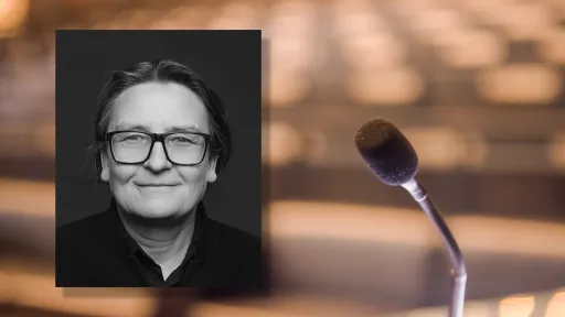 Portrettfoto av Ragnhild Hennum, dekan ved UiO, mot bakgrunn med mikrofon og tomme stolrader