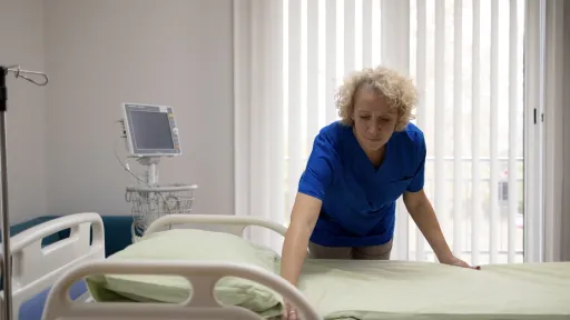 Voksen kvinne rer opp sykehusseng