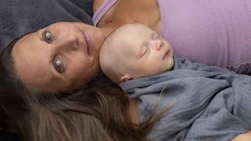 Godt voksen kvinne ligger med sovende baby på brystet