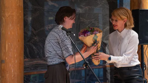 Prisvinner Eva van der Kooji (t.v.) får blomster av jurymedlem Ania Malinowska