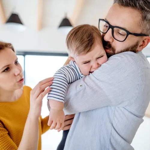 kvinne og mann trøster et gråtende barn