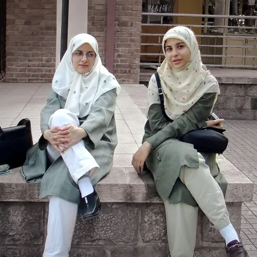 To kvinner med hijab som sitter på en benk
