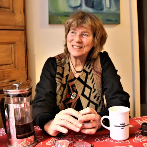 Johanne Sundby ved bordet med en kopp kaffe