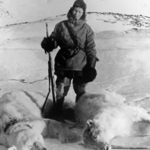 Polarfarer med to døde dyr ved føttene.