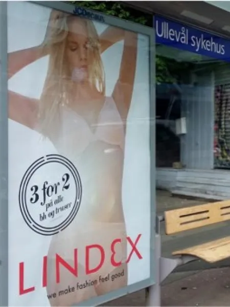 Busstopp med reklameplakat.